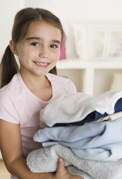 Young girl holding laundry.