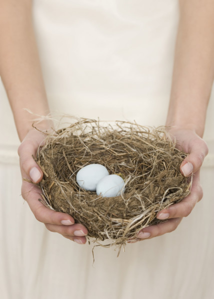 Female holding nest with eggs.