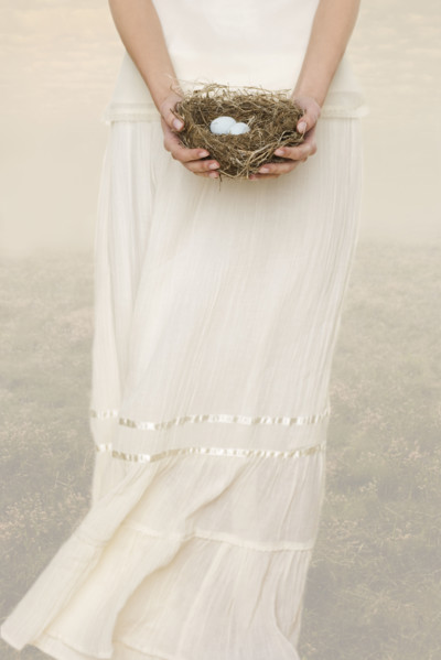 Female holding nest with eggs.