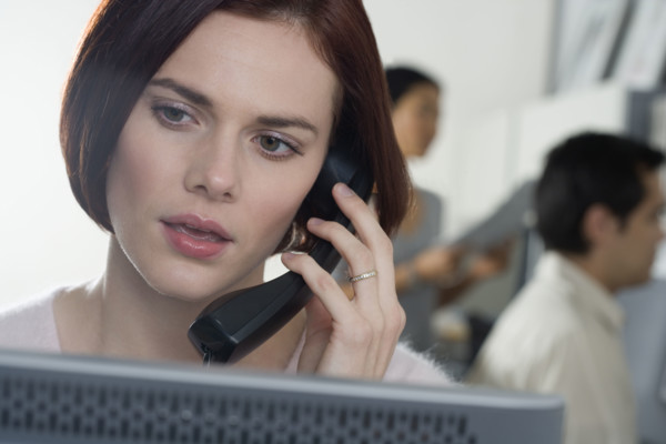 Woman talking on phone in office.