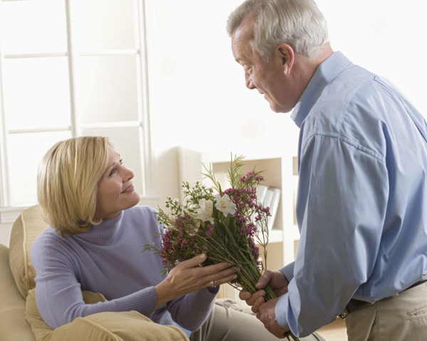 Man giving flowers to his wife.