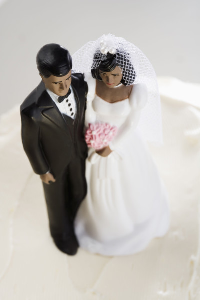 Bride and groom on top of wedding cake.