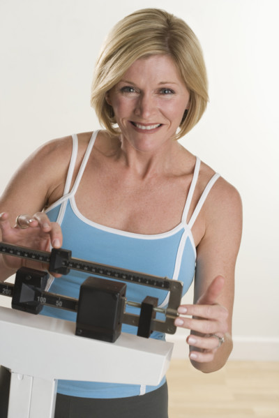 Portrait of woman weighing herself.