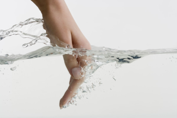 Hand dipping into water.