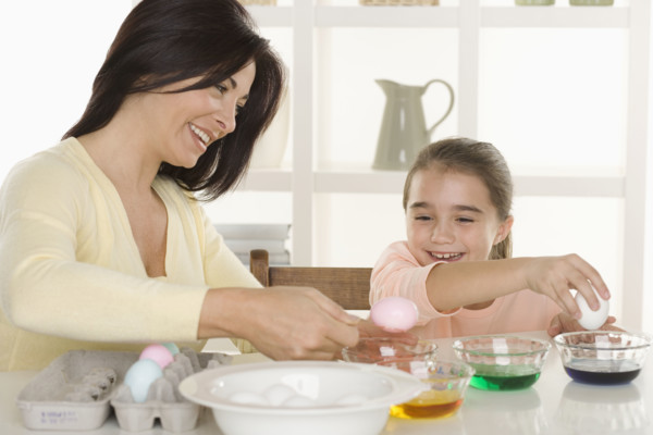 Mother and daughter coloring Easter eggs.