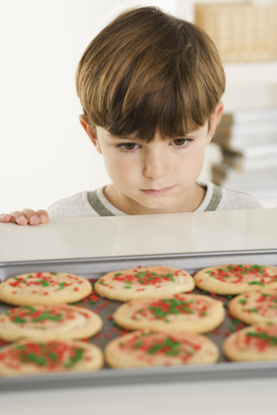 Little boy eyeing cookies.