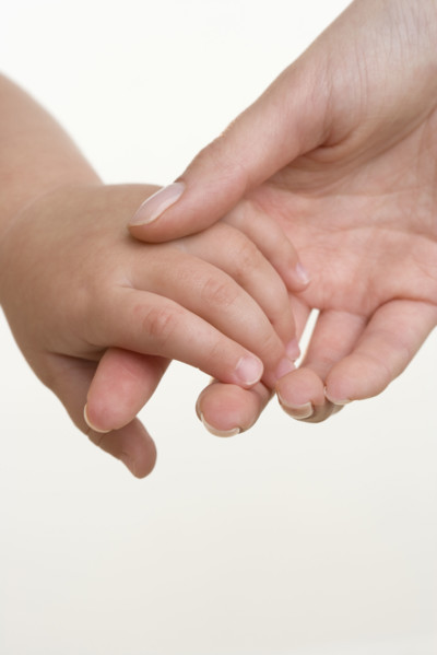 Baby holding hands with mother.