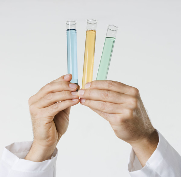 Hand holding test tubes.