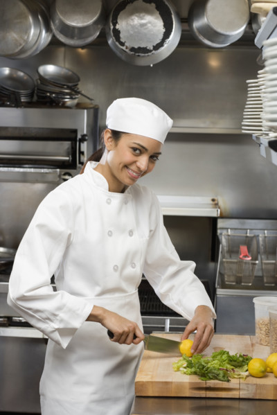 Female chef in restaurant kitchen.
