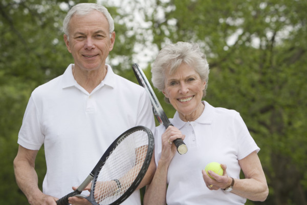 Portrait of mature couple with tennis racquets.