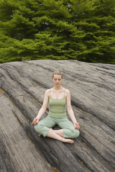 Woman practicing yoga in park.