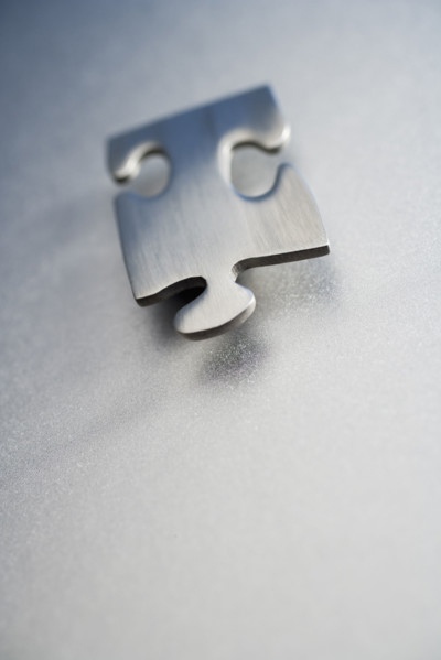 Angled metallic jigsaw puzzle piece .