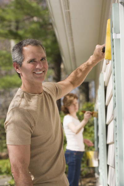 Man painting exterior of house.