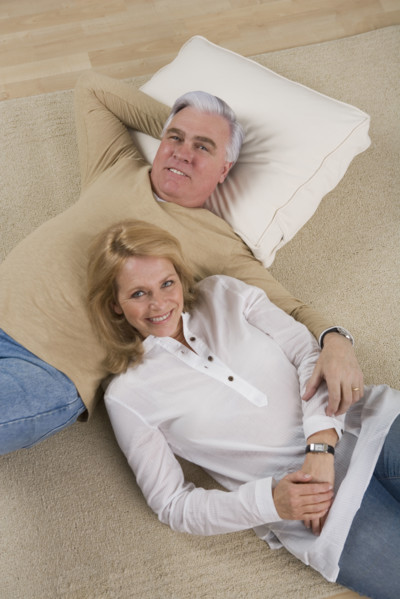 Senior couple lying on floor.