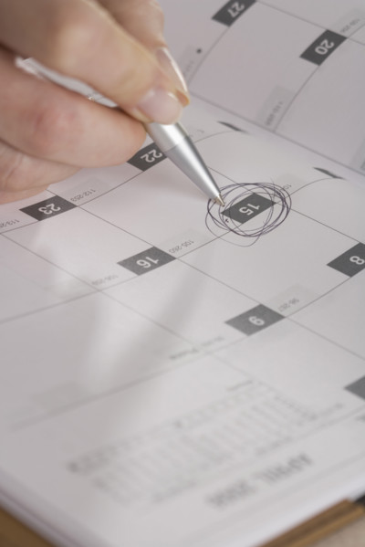 Woman marking day on calendar.