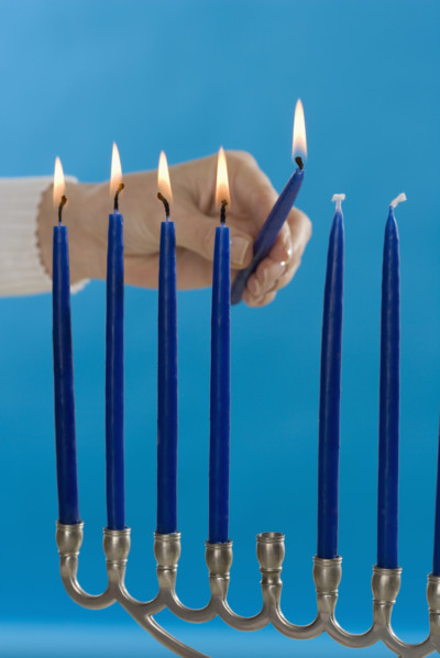 Woman lighting a Menorah.