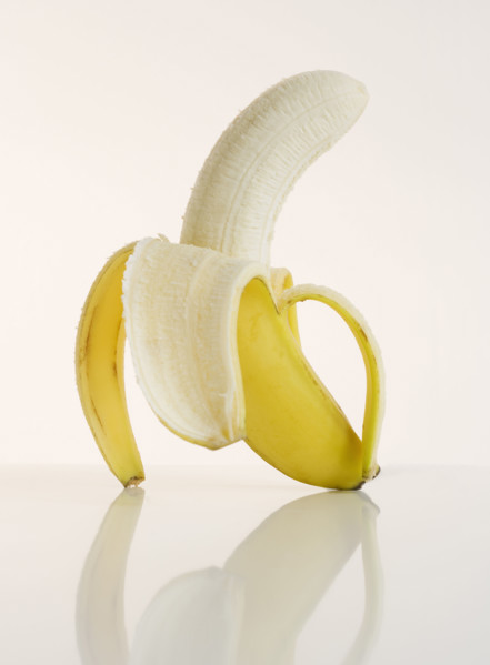 Studio shot of half peeled banana.