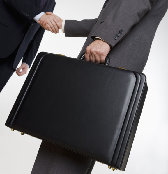 Businessman with briefcase shaking hands.