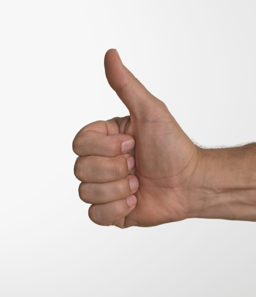 Studio shot of man's hand giving thumbs up.