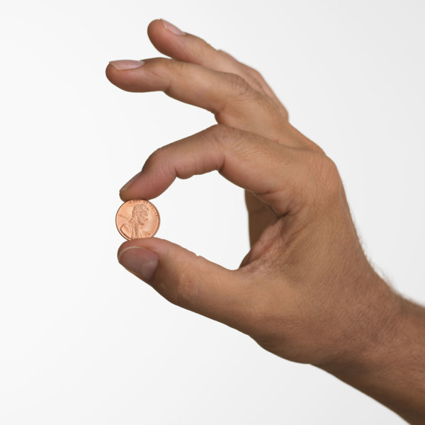 Close up studio shot of man holding penny.