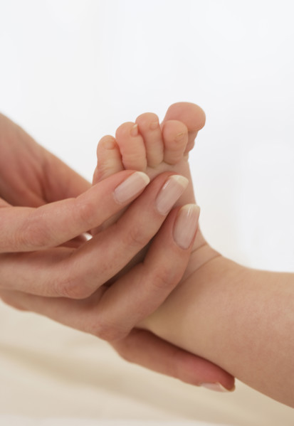 Mother holding baby’s foot.