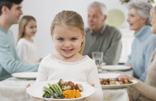 Portrait of girl holding plate at Thanksgiving.