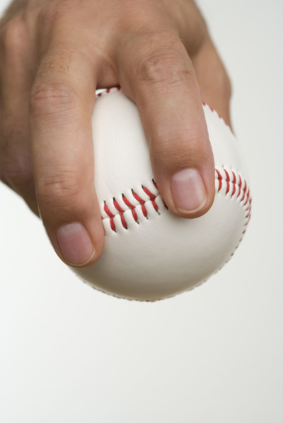 Close up of pitcher holding baseball.