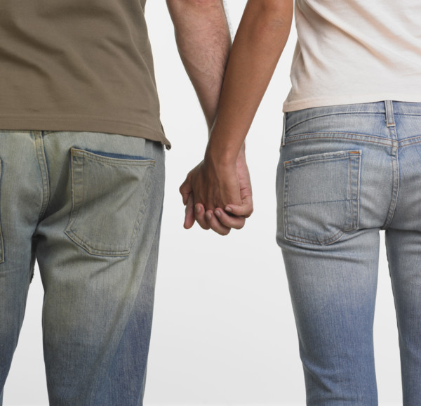 Rear view of couple holding hands.