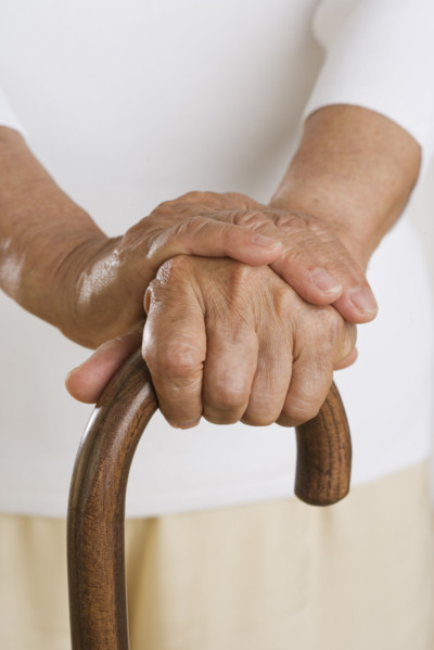 Close up of senior's hands on cane.