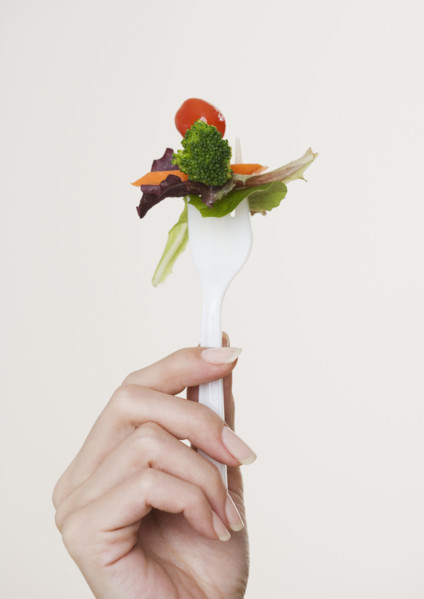 Close up of salad on fork.