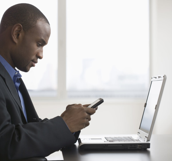 Businessman dialing cell phone.