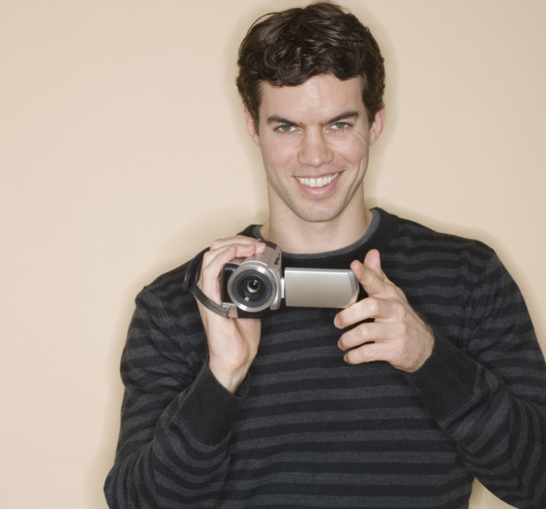 Portrait of man holding video camera.