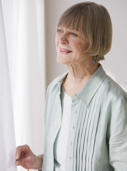 Senior woman looking out window.