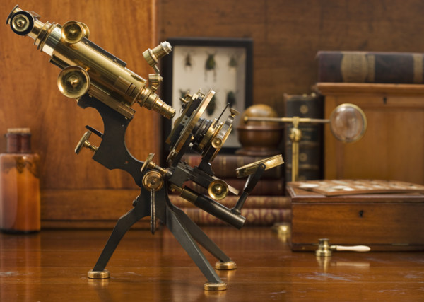 Old fashioned microscope on table.