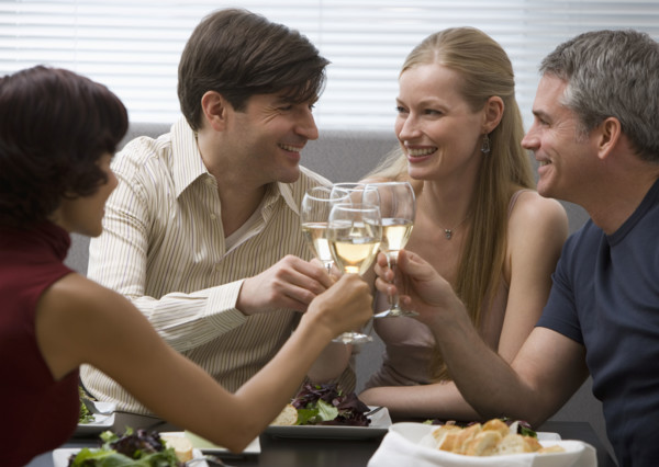 Two couples toasting at restaurant.