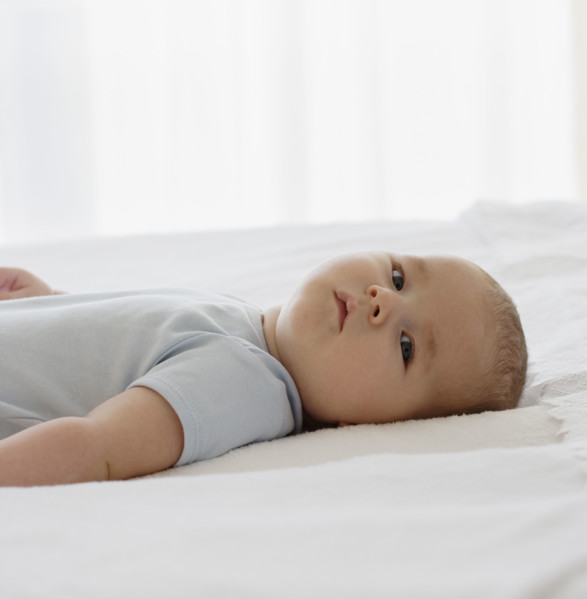 Baby laying on bed.