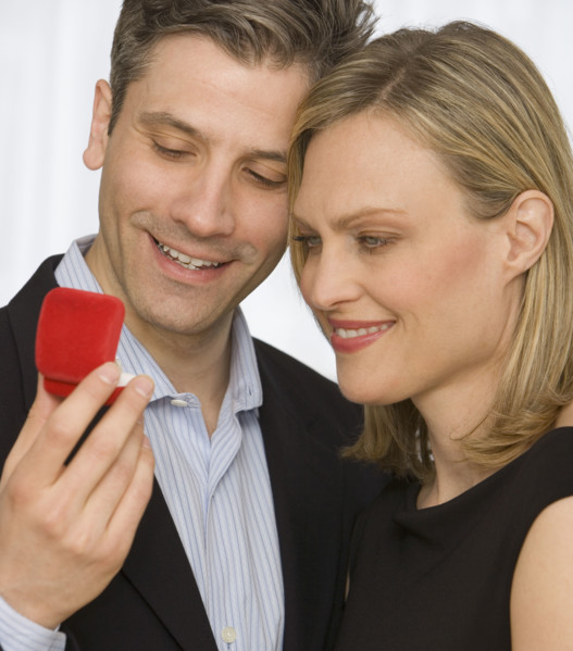 Couple looking at ring box.