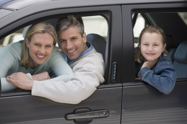 Family smiling in car.