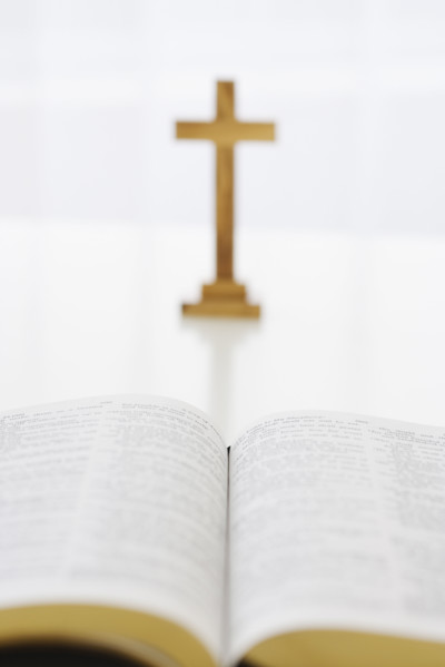 Open book and cross in background.
