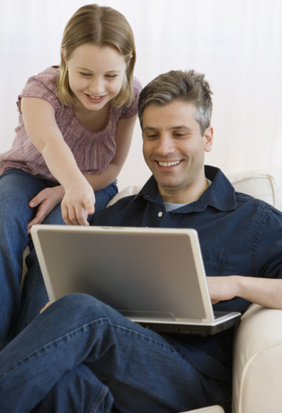 Father and daughter looking at laptop.