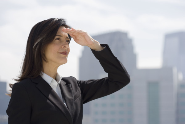 Businesswoman shielding eyes from sun.