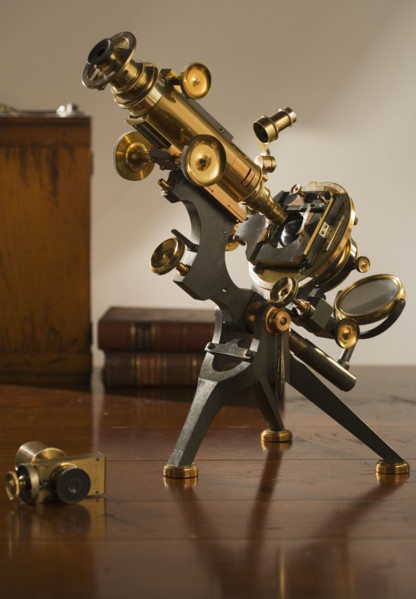 Old fashioned microscope on table.