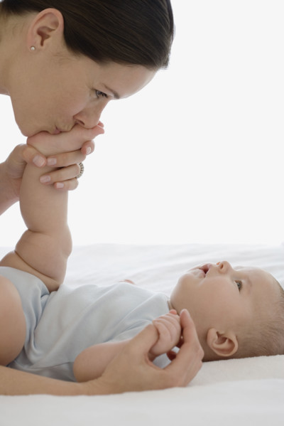 Mother kissing baby’s foot.
