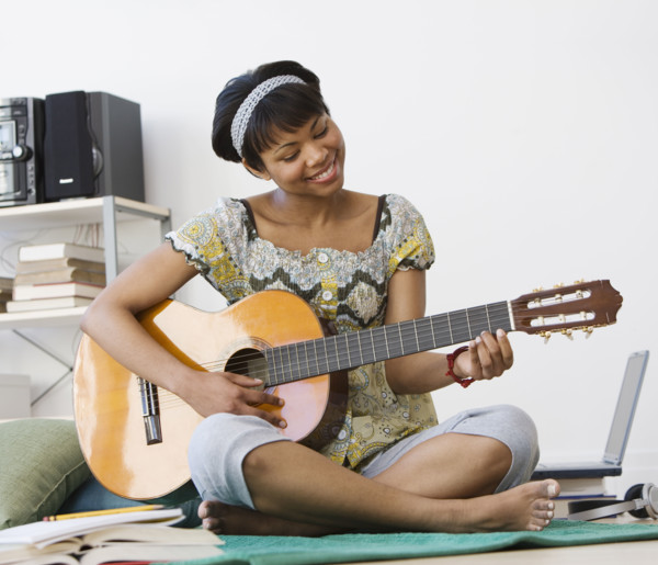 African woman playing acoustic guitar.