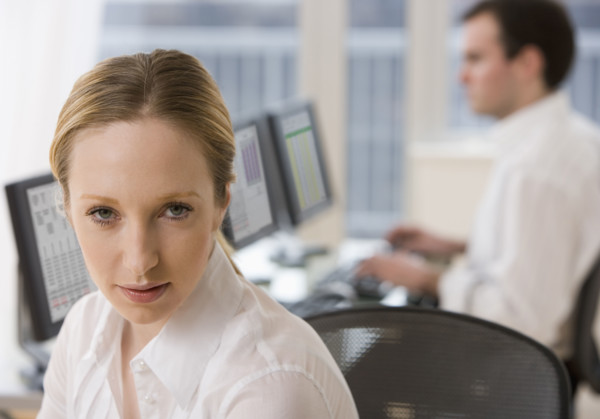 Businesswoman with co-worker in background.