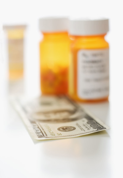 Money in front of medication bottles.