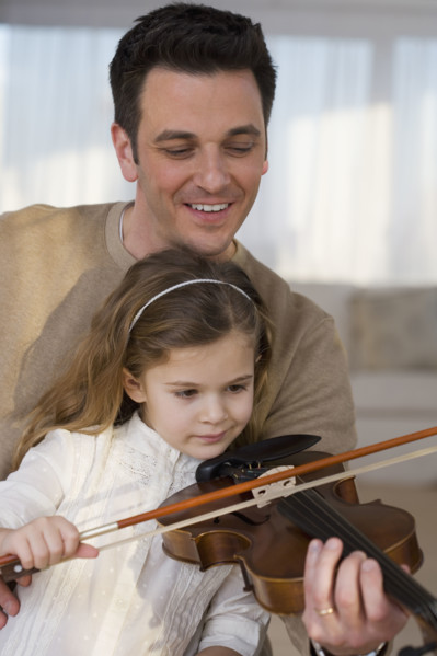 Father helping daughter play violin.