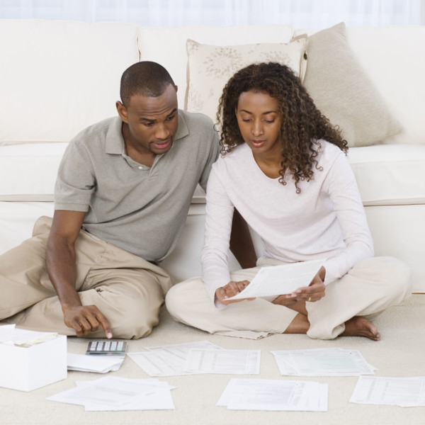 Couple paying bills on floor.