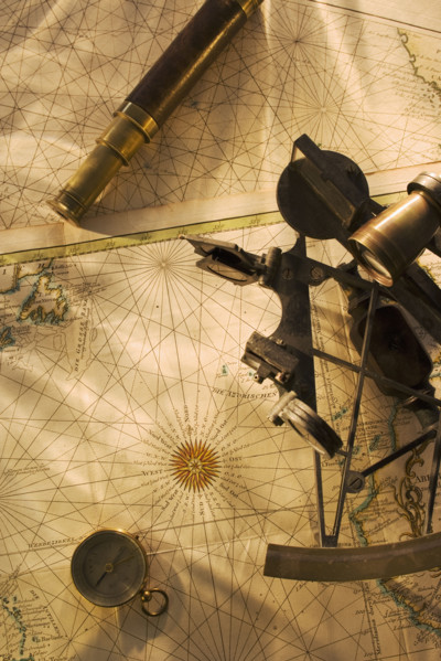 Octant, compass and telescope on nautical map.