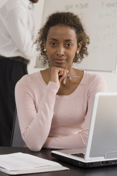 Portrait of businesswoman next to laptop.